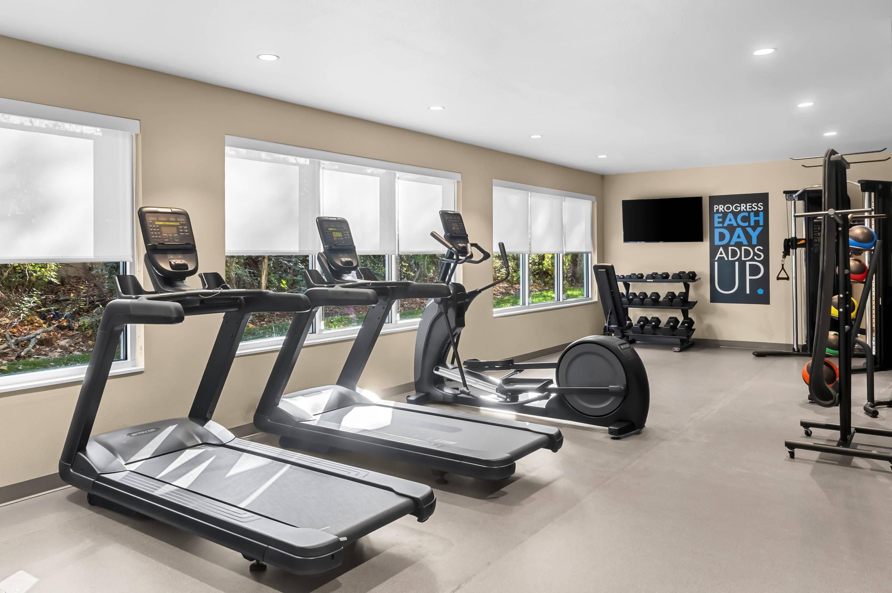 A gym with treadmills, an elliptical, and a weight machine.