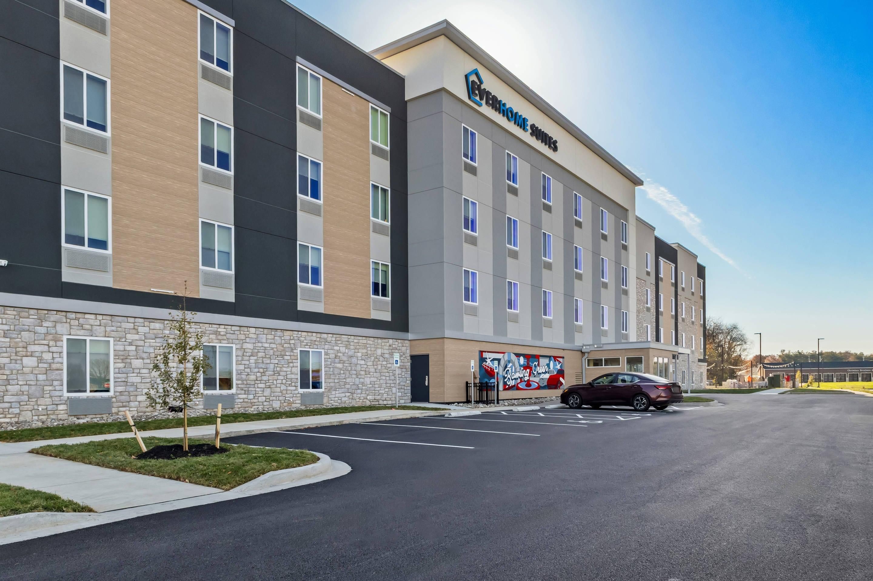 A multi-story hotel with a stone facade and a parking lot.