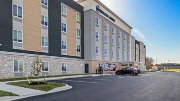 A multi-story hotel with a stone facade and a parking lot.