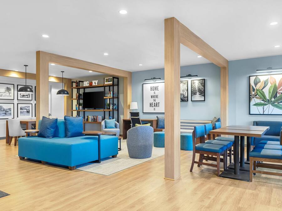A modern living room with a blue sofa, a wooden coffee table, and a bookshelf.
