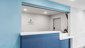 Un mostrador de recepción con un cartel para el hotel Woodspring Extended Stay.