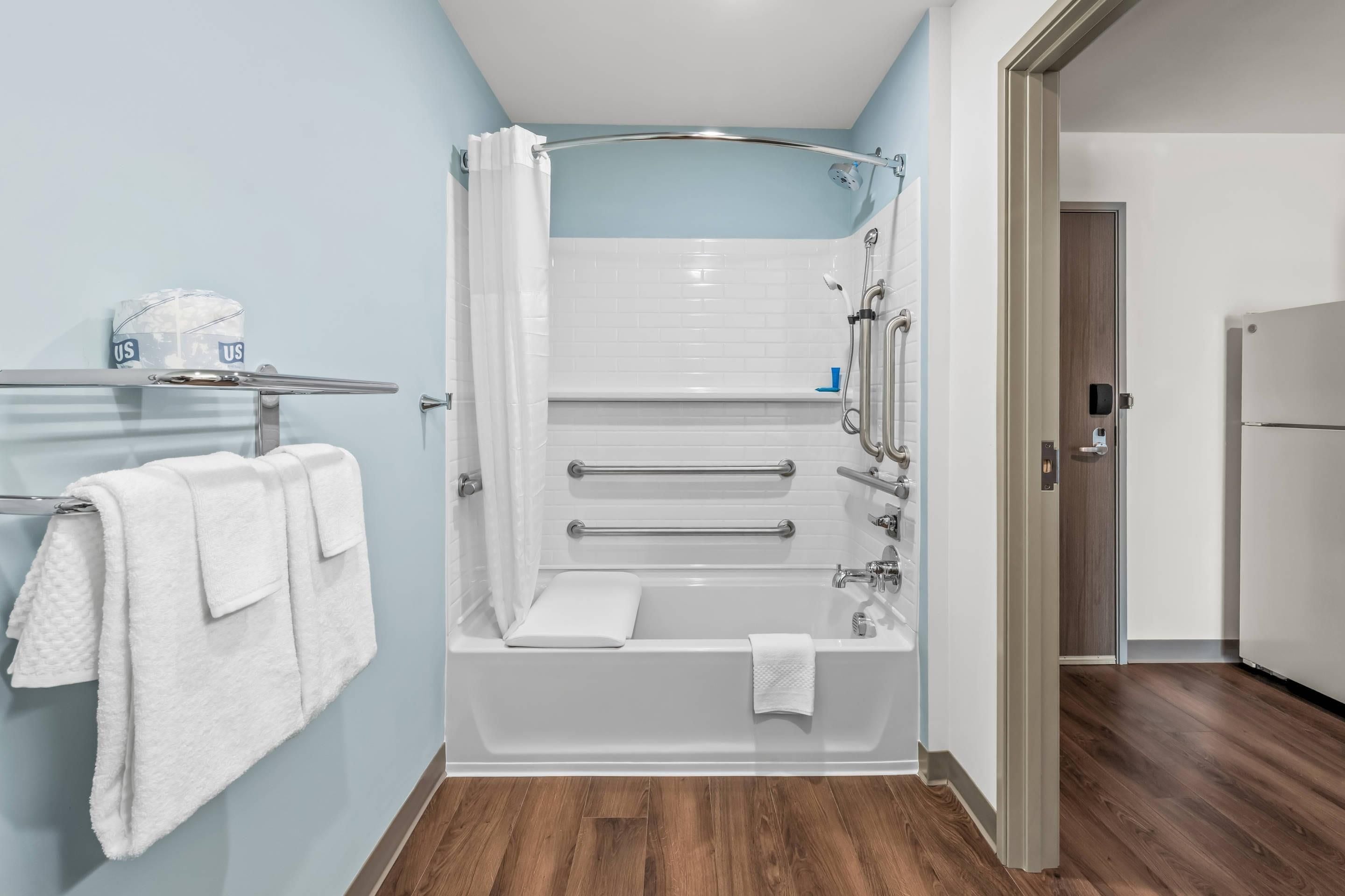 Un baño moderno con bañera, ducha y un perchero para toallas.