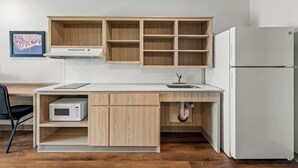 Una cocina moderna con gabinetes de madera, un refrigerador blanco y un microondas.