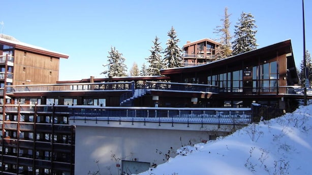 A modern ski resort building with multiple levels, large windows, and a covered outdoor area. - 3-room Apartment for 6 People With a Lovely View of the Valley, Close to the Cable car in the Village of Charmettoger in A (Bourg-Saint-Maurice)
