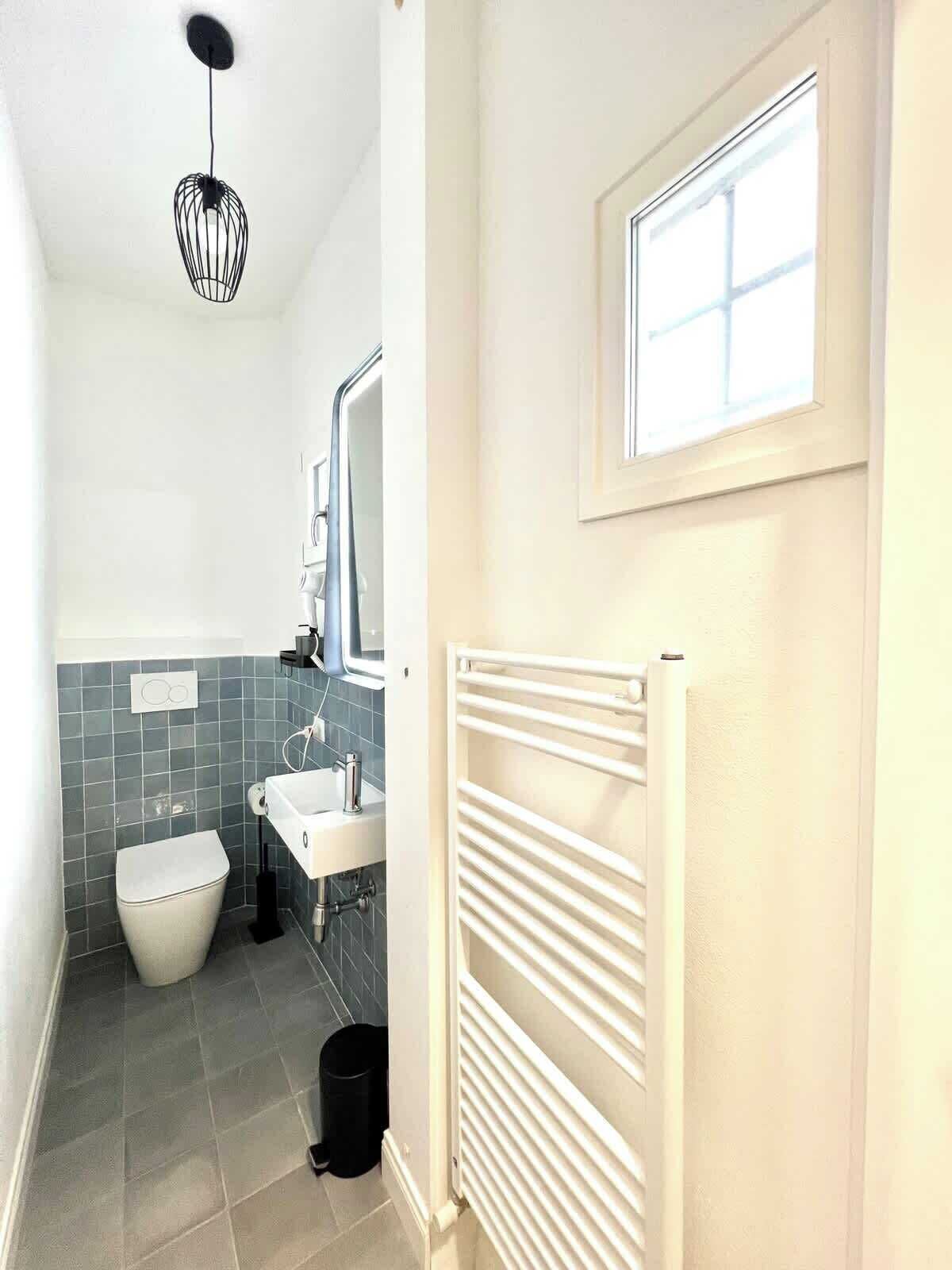 A compact bathroom with a toilet, sink, and mirror.