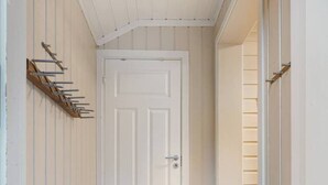 A narrow hallway with a wooden floor, white walls, and a white door at the end. - Trysil Ski-in/out, Sauna, Groups (Trysil)
