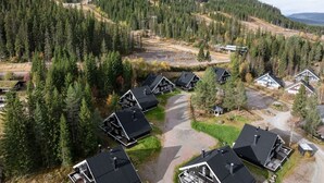 A residential area with multiple houses, surrounded by dense forest and hills. - Trysil Ski-in/out, Sauna, Groups (Trysil)