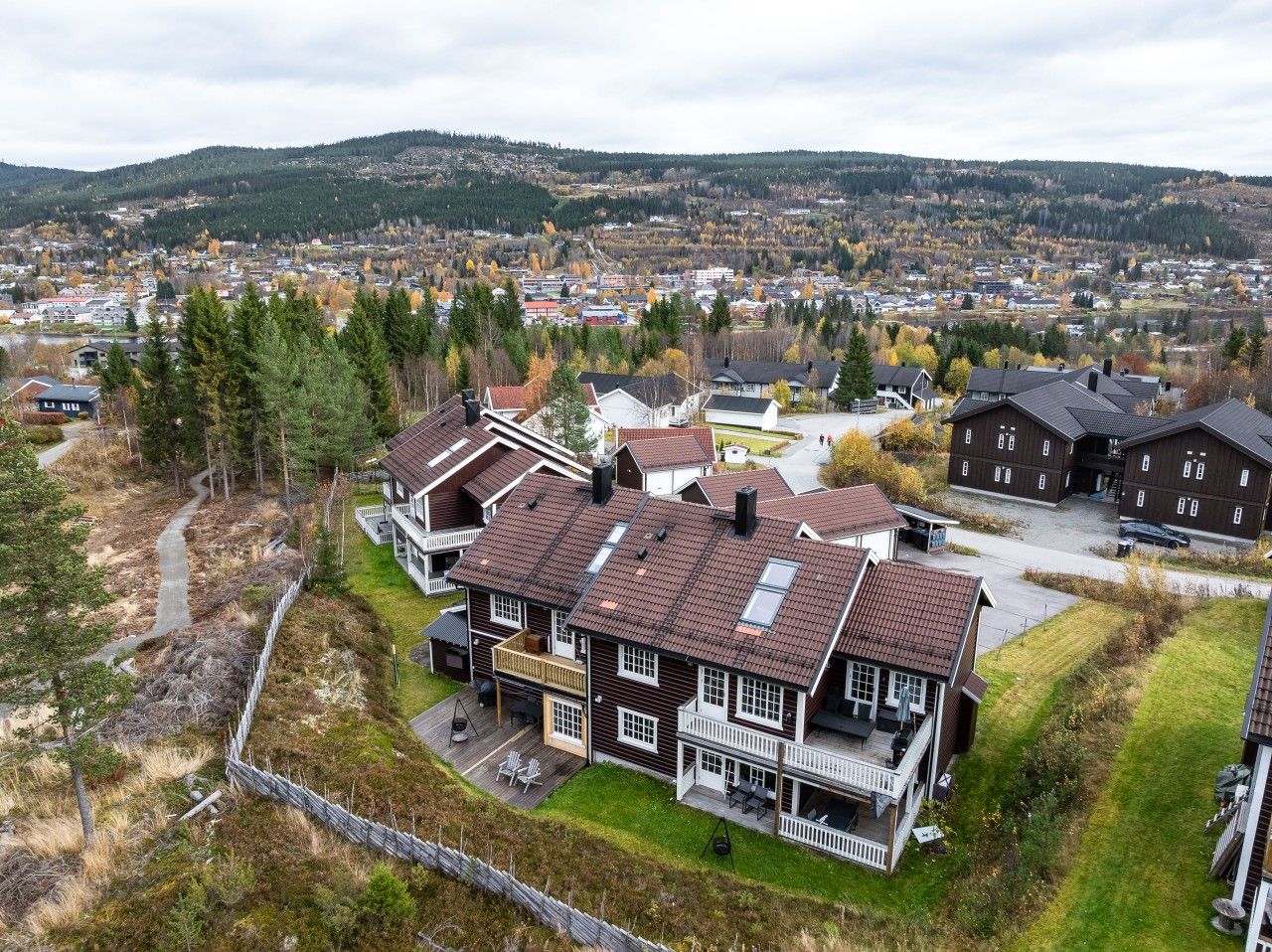 Una zona residenziale con diverse case, un vialetto lastricato e vista su una città in lontananza.