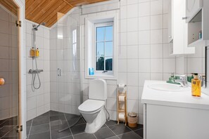 Une salle de bain moderne équipée d’une douche, de toilettes et d’un lavabo.