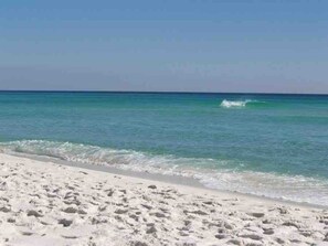 Una playa con arena blanca y agua azul cristalina.