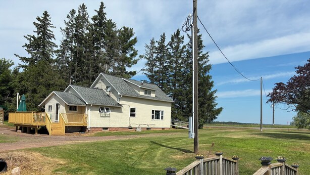 A two-story house with a deck and a wooden bridge leading to it. - Back to the Old Farm (Ashland)