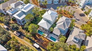 Un quartier résidentiel avec des maisons, une piscine et des palmiers.