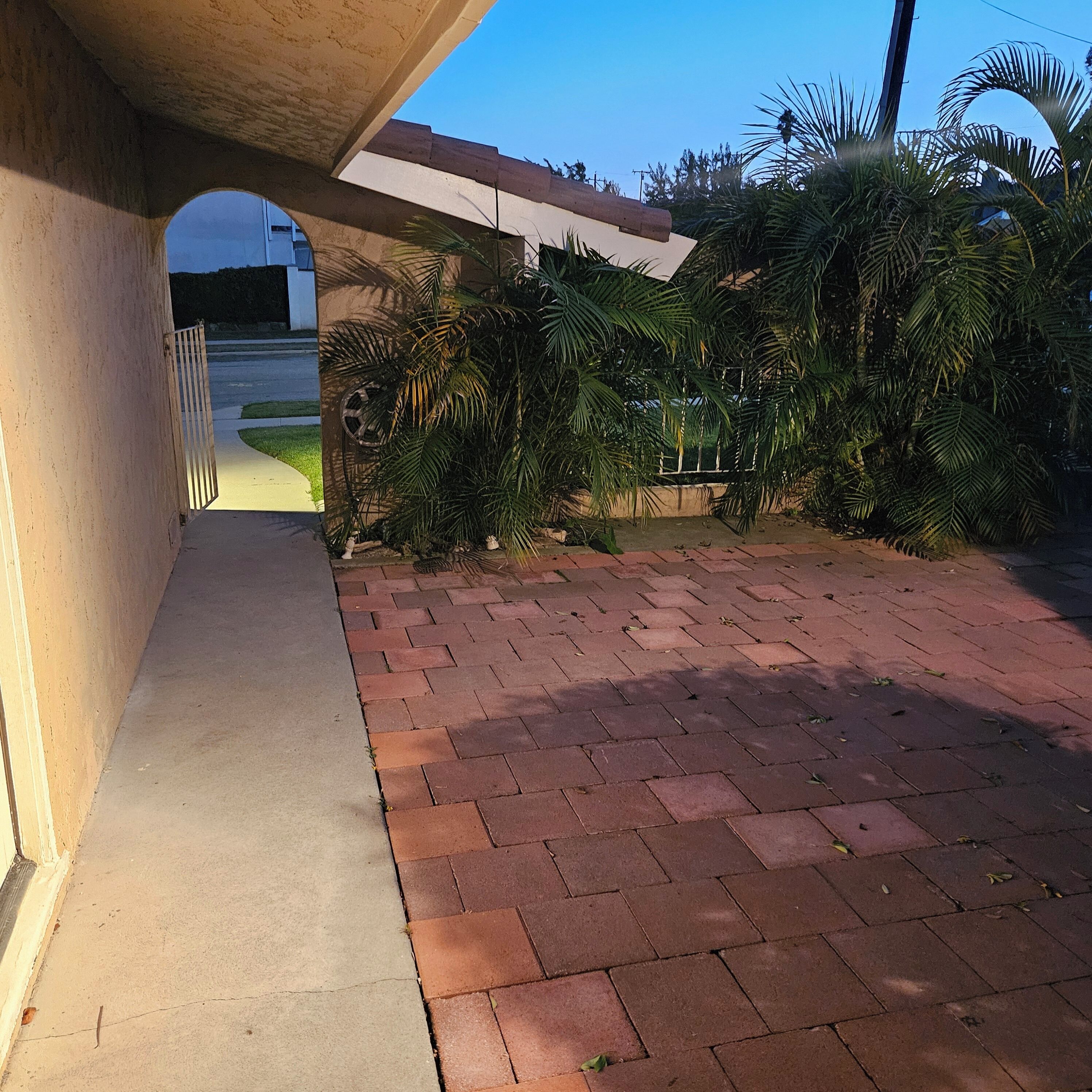 A paved walkway under a bridge, leading to a building entrance.