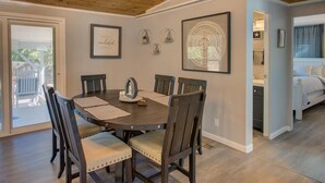 Uma sala de jantar com mesa de madeira, cadeiras e teto com vigas de madeira.