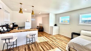 Un appartement moderne doté d’une cuisine, d’un coin repas et d’un grand lit.