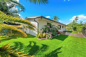A house with a well-maintained lawn, a porch with plants, and a clear blue sky. - Casa Verde - 5 BDRM / 2 BA with POOL + HOT TUB (Miami)