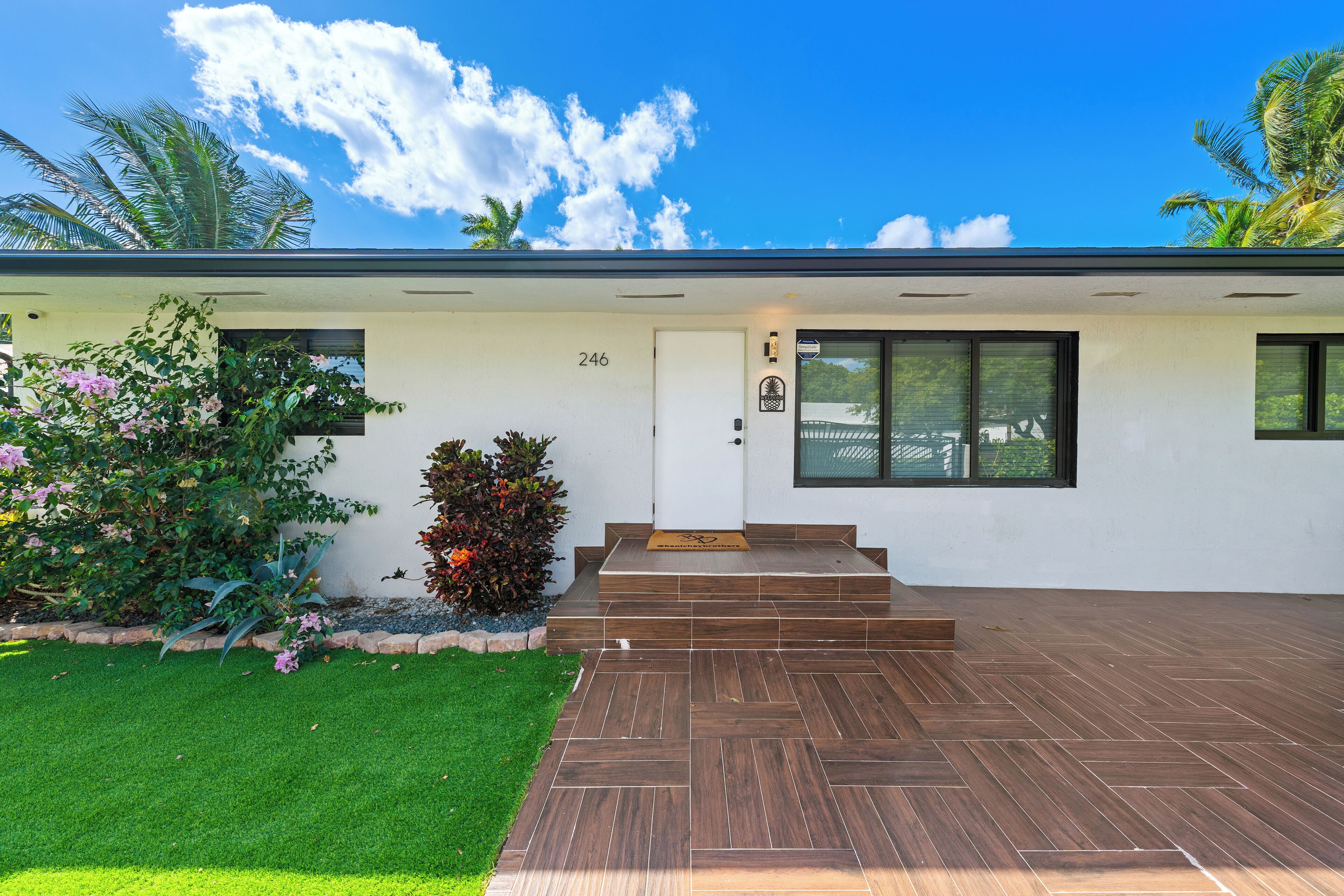 Une maison moderne, portant le numéro 246, avec un porche à l’avant et une pelouse bien entretenue.