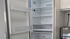 An open refrigerator with multiple shelves, a built-in water dispenser, and a freezer drawer. - Apartment near the airport, The Greey's house D (El Calero)