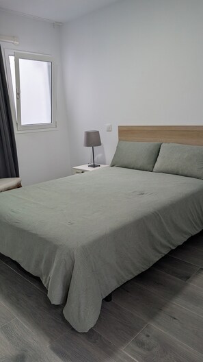 Tabla de planchar con plancha, internet y ropa de cama