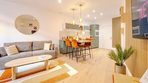 Una sala de estar moderna con sofá, mesa de centro y comedor.