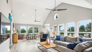 A spacious living room with a high ceiling, large windows, and a modern design. - NEW! Lake View • Pool + Spa • Game Room • Fire Pit • Near Marina & Wineries (Canyon Lake)