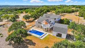 A large house with a swimming pool, surrounded by trees and a hilly landscape. - NEW! Lake View • Pool + Spa • Game Room • Fire Pit • Near Marina & Wineries (Canyon Lake)