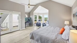 A bedroom with a large bed, a ceiling fan, and a view of the outdoors through a sliding door. - NEW! Lake View • Pool + Spa • Game Room • Fire Pit • Near Marina & Wineries (Canyon Lake)