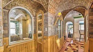 Un pasillo con paneles de madera, arcos y una alfombra estampada.