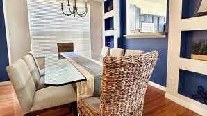 A dining area with a table, chairs, and a chandelier.