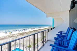 A balcony with a view of a beach and ocean.