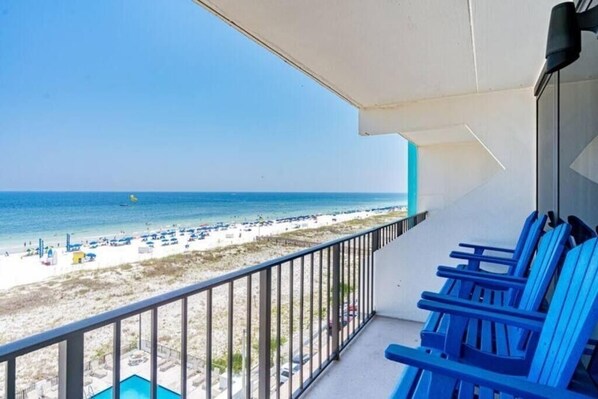 A balcony with a view of a beach and ocean.