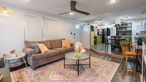 Ein Wohnzimmer mit Sofa, Couchtisch und einem Essbereich mit Stühlen und einem Tisch.