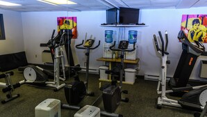 A gym with various exercise equipment, including treadmills, stationary bikes, and weight machines.