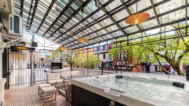 A hot tub with a view of the city, a grill, and outdoor seating. - Charming Stay-3 min walk to metro (Montréal)