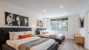 A modern hotel room with two beds, a large window, and artwork on the walls. - The Zen Cityscape: Charming 1 BR Apt in DT MTL (Montréal)