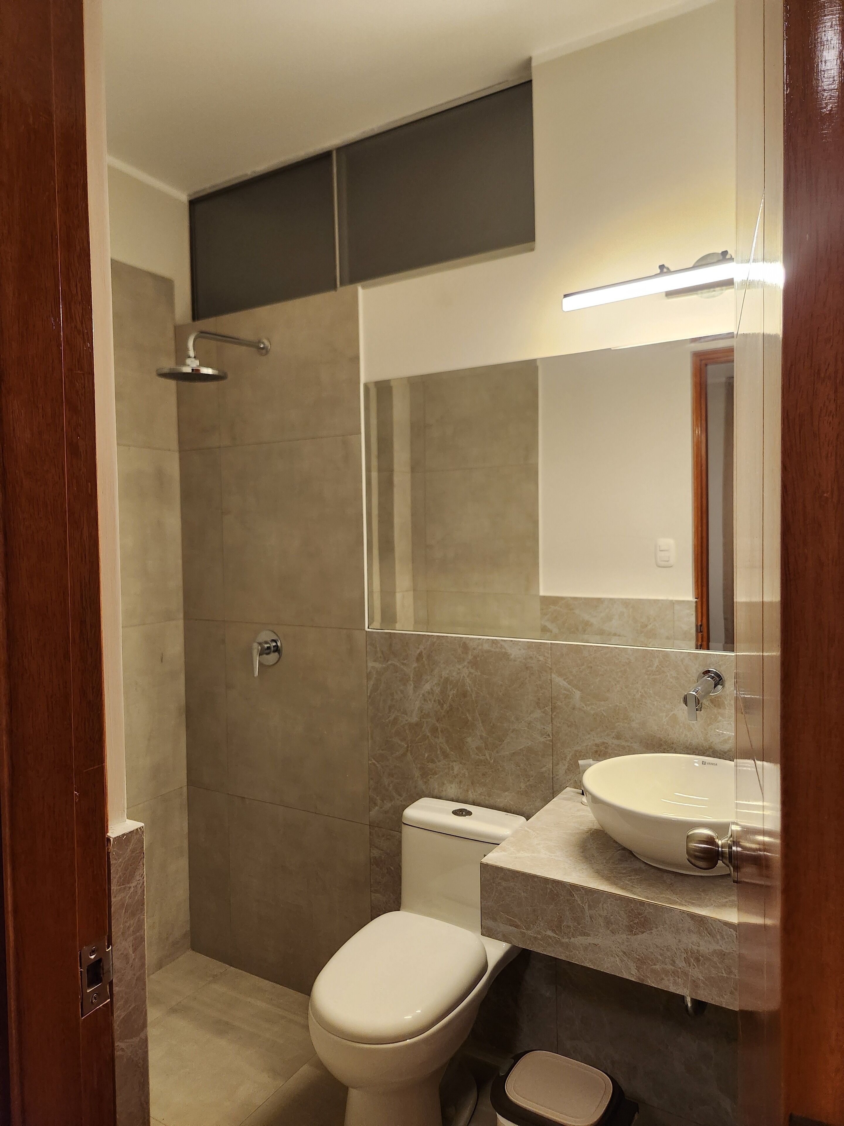 Un baño moderno con ducha, inodoro y lavamanos.