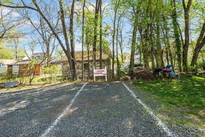 A gravel driveway leading to a wooden cabin with a sign indicating 'Airbnb Parking.' - Spacious 3BR 4 Beds Sleeps 8 Near Train Bus 112 Easy NYC Access (Roselle)