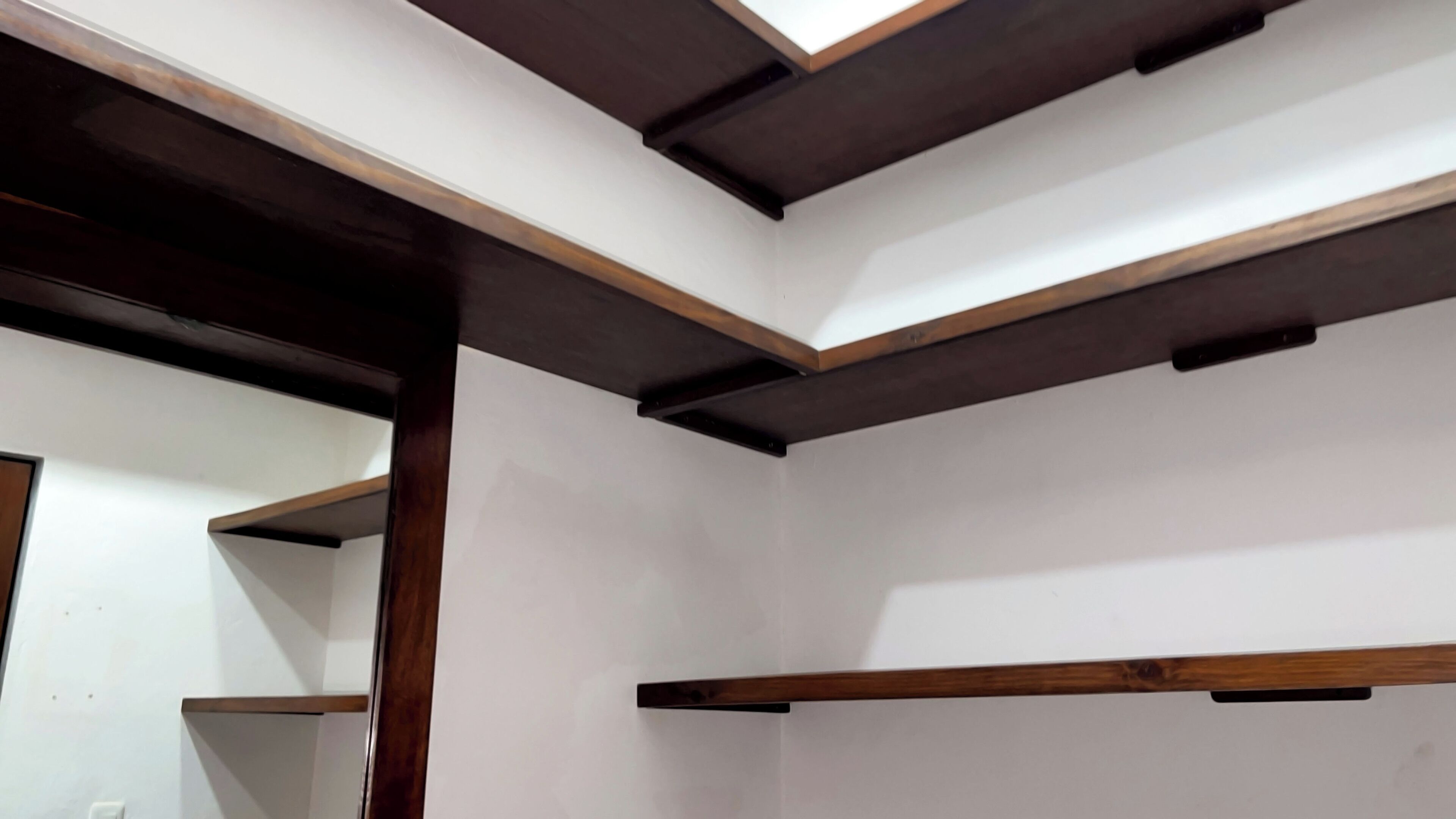 Una habitación con vigas de madera a la vista y paredes blancas.