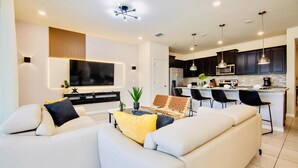 Ein modernes Wohnzimmer mit einem weißen Sofa, einem Couchtisch und einem Fernseher.