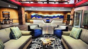 A modern lobby with a central seating area, a mural on the back wall, and a mix of seating options.