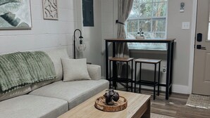 Un salon moderne avec un canapé, une table basse et un coin repas.