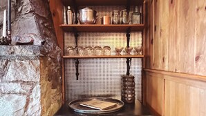 A wooden interior with shelves holding kitchenware, a framed picture, and a log storage area. - Cozy lake-view cabin in Carnelian Bay (Carnelian Bay)