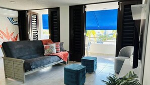 A modern living room with a sofa, ottomans, and a chair. - Your getaway space walking distance to the beach (Luquillo Luquillo)