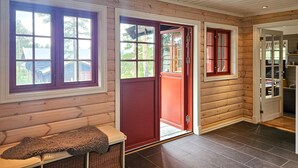 A log cabin interior with a bench, wicker baskets, and a red door. - Gorgeous home in Eggedal with sauna (Eggedal)