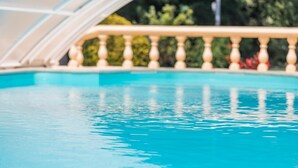 On voit clairement une piscine, bordée d’une balustrade en bois.