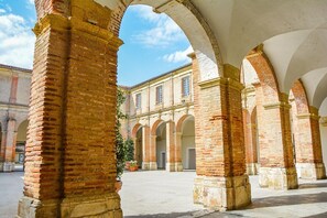 A courtyard with brick arches and a building in the background. - Bachalé - LAMOTHE - Vacation Home   (LAMOTHE)