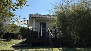 Een klein, laag huis met een veranda en een trap naar de voordeur.