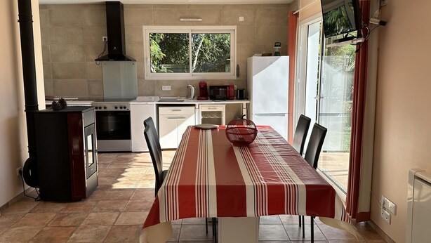 Een moderne keuken met een eettafel, stoelen en uitzicht op het landschap.
