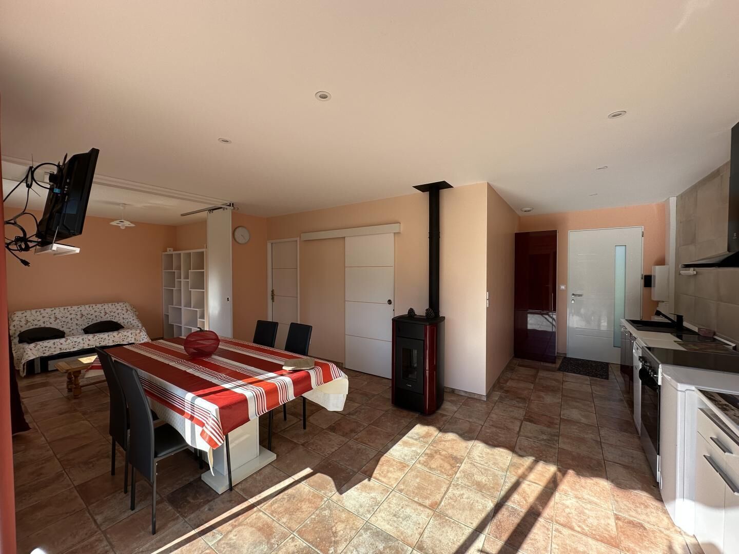 A spacious living area with a dining table, a fireplace, and a kitchen.