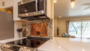 A modern kitchen with a built-in microwave, stove, and a decorative backsplash. - Peaceful Hillside Home with 3BD:2BTH & 30 Mins to Yosemite (Oakhurst)